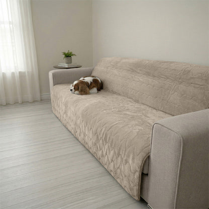 A small brown and white dog resting on a Gray Paw Inspired Anti-Slip Furniture Protector. The quilted, waterproof cover is shown protecting a modern fabric sofa from pet hair and messes.