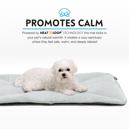 A Maltese relaxing snugly on a tan Paw Inspired self-heating crate mat.