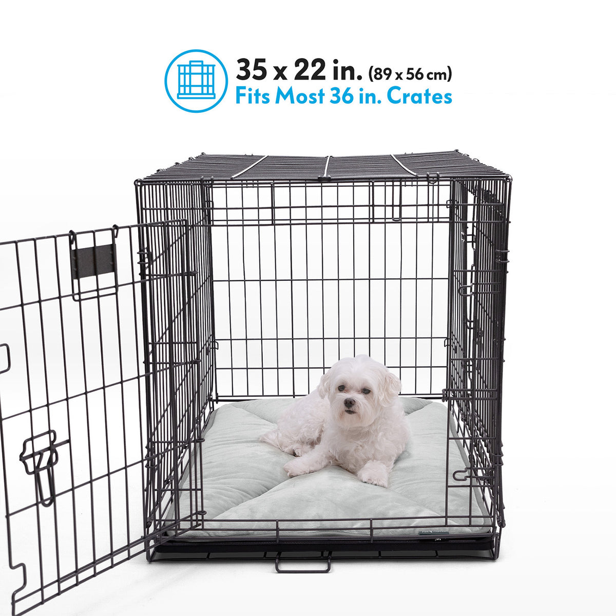 A Shetland Sheepdog resting on a gray Paw Inspired self-heating crate liner measuring 35 by 22 inches inside a 36-inch wire crate.