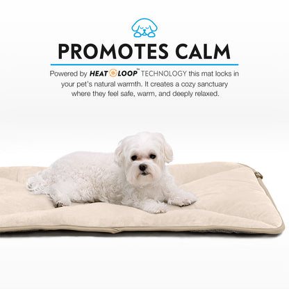 A Maltese relaxing snugly on a tan Paw Inspired self-heating crate mat.
