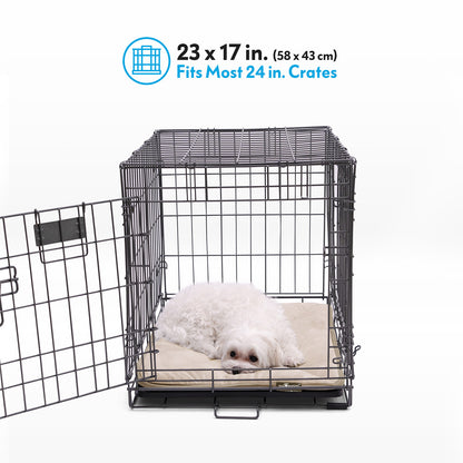 A white dog resting on a tan Paw Inspired self-heating crate liner measuring 23 by 17 inches inside a 24-inch wire crate.