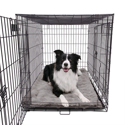A Border Collie lying comfortably on a Paw Inspired large grey waterproof faux fur blanket (50x60 in) used as a protective and cozy dog crate mat.