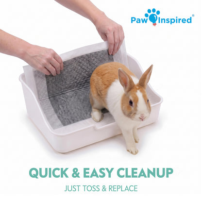 A person placing a gray carbon pad into a white small animal litter pan with a rabbit standing inside, demonstrating the quick and easy cleanup by tossing and replacing the liner.
